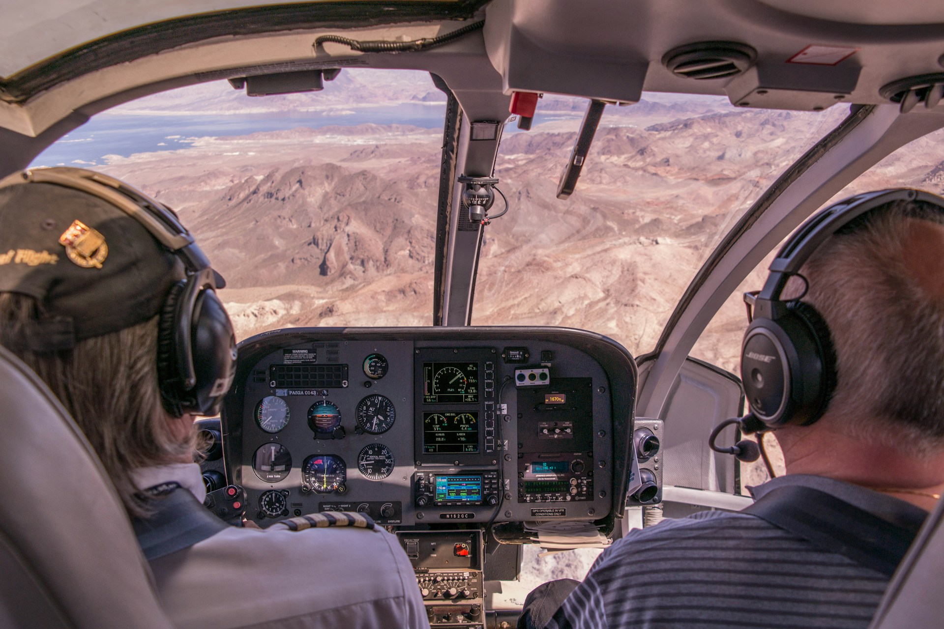 A pilot flying over mountainous terrain during sunset