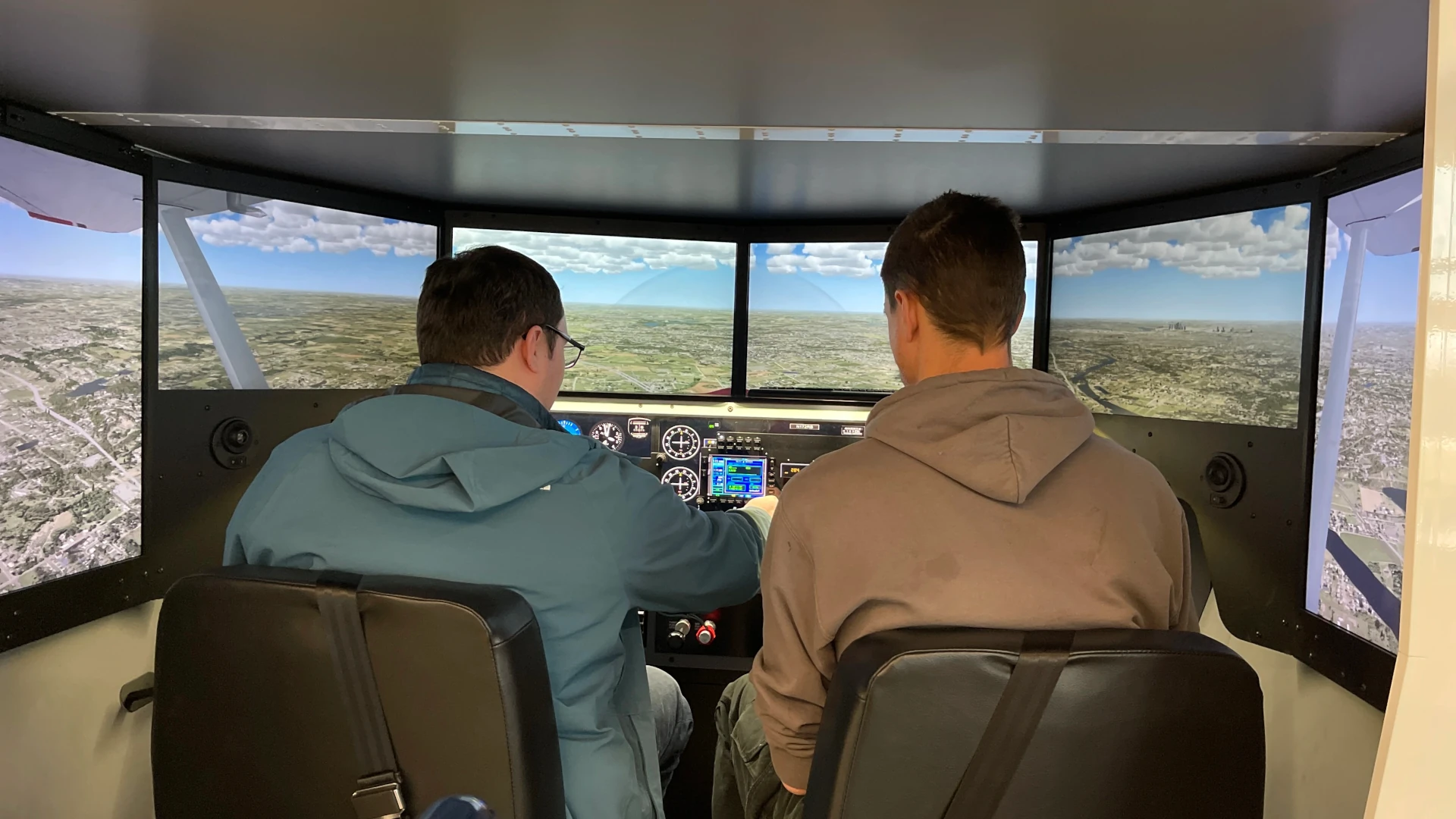 A student trains in the Redbird flight simulator to learn the basics of flight training before a flight.